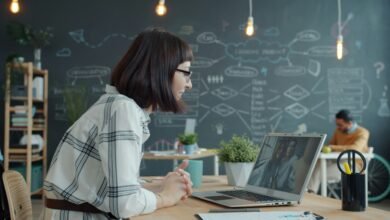 A professional woman uses cloud telephony on her laptop for business communication with a client in an office.